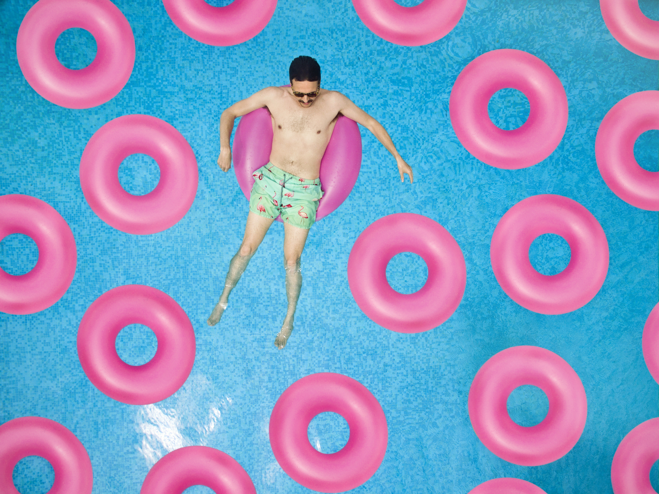 Guy On Pink Pool Floats